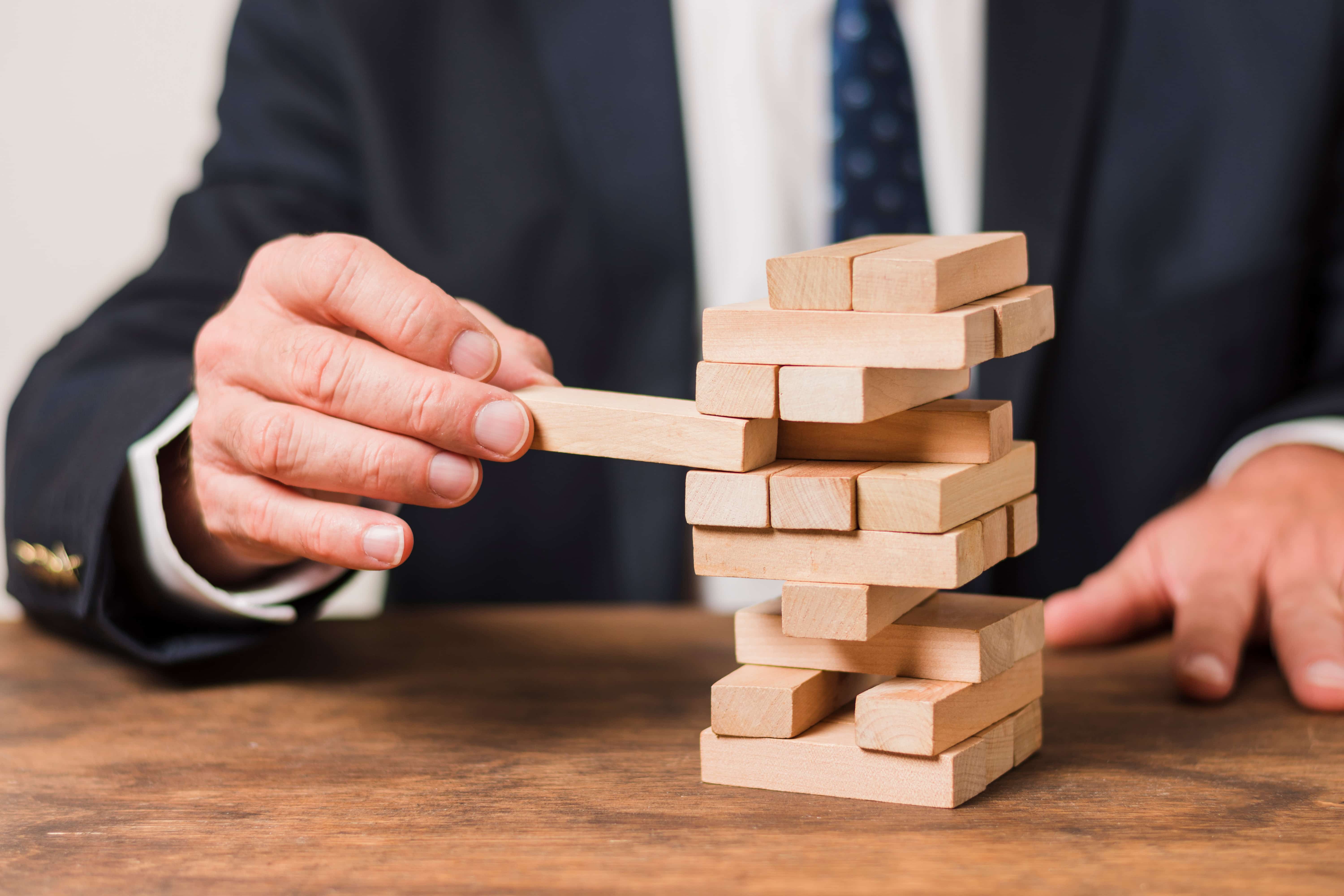 A businessman playing Jenga. - Jerone Toledo Frente
